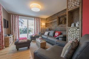 奥伯斯特多夫Chalet Alpin的客厅设有真皮沙发和木墙