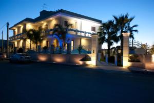 曼杜里亚圣保罗酒店 的一座棕榈树掩映的白色房子