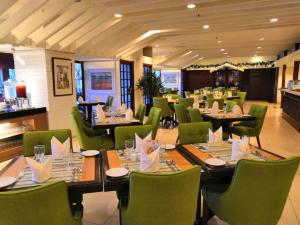 怡保怡保宴宾雅酒店的用餐室配有桌子和绿色椅子
