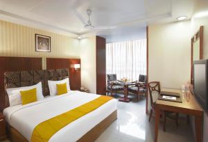 孟买苏巴宫酒店的酒店客房设有一张大床和一张桌子。