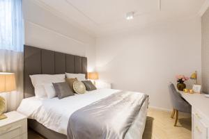 萨格勒布MM House的一间卧室配有一张白色大床和黑色床头板