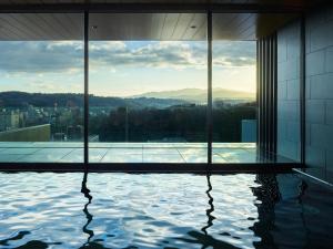 金泽Mitsui Garden Hotel Kanazawa的一座游泳池,位于一座享有城市美景的建筑内