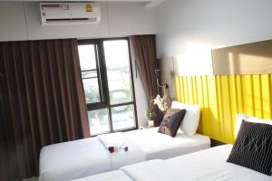 巴吞他尼Bangkok Boutique Resort Rangsit的酒店客房设有两张床和窗户。