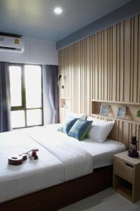 巴吞他尼Bangkok Boutique Resort Rangsit的卧室配有一张大白色床和窗户
