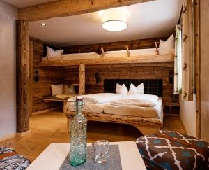 希洛谢克Auenhütte的客房设有两张双层床和一张桌子上的一瓶