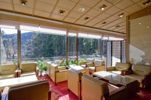 日光清晃苑日式旅馆的餐厅设有桌椅和大窗户。