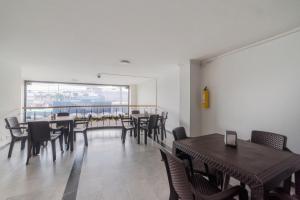 波哥大Ayenda 1030 Elegant Suite的一间带桌椅的用餐室和大窗户
