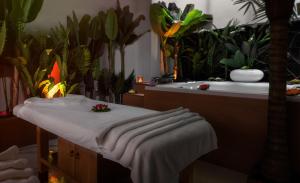 雅典Elia Ermou Athens Hotel的一间带植物和浴缸及桌子的浴室