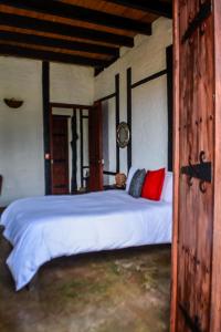 萨兰托Coffee Tree Boutique Hostel的卧室配有带红色枕头的大型白色床