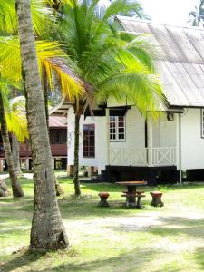 珍拉丁Maznah Guest House的一座带野餐桌和棕榈树的建筑