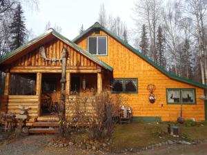 Trapper CreekAlaska's Northland Inn的小木屋,设有绿色屋顶