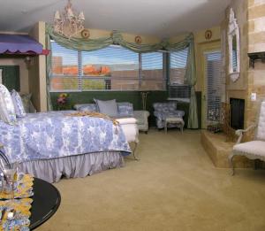 塞多纳奥多比大别墅酒店的一间卧室配有一张床、一张沙发和一个壁炉
