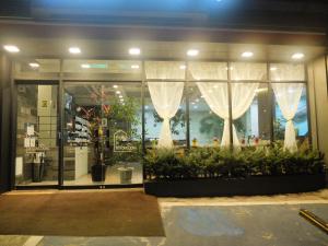 首尔爱华明洞酒店的商店前方设有窗户,窗户上布满了窗帘和植物