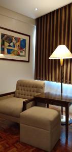 马尼拉Tropicana Suites的带沙发、桌子和台灯的客厅