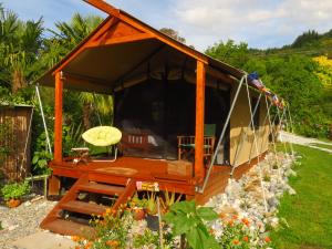 PoharaOmarama Oasis - Permaculture Glamping的花园内带长凳的凉亭