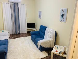 马科普隆Small Apartment in Markopoulo center的客厅配有蓝色的沙发和电视
