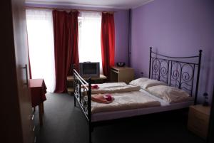 布拉迪斯拉发拉塔诺膳食公寓的一间卧室配有一张粉红色的墙壁和窗户。