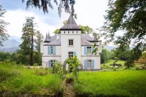 Sévignacq-MeyracqChâteau de Druon的绿色田野上一座白色的老房子,塔楼