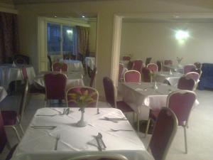 开罗开罗坎兹酒店的用餐室配有白色的桌子和红色的椅子