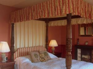 Clutton猎人休息酒店的一间卧室配有带泰迪熊的天蓬床
