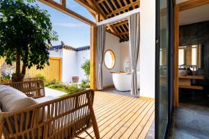 张家界Su Xin Resort Inn的木甲板设有浴缸和浴室
