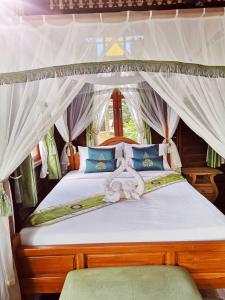 彭世洛Baan Sithepaban Guesthouse的一间卧室配有一张带蓝色枕头的天蓬床