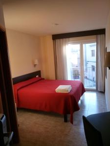 阿诺亚河畔圣萨杜尔尼桑特萨杜尔尼旅馆的一间卧室设有红色的床和大窗户