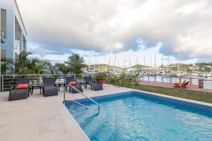 格罗斯岛Waters Edge Villas by Bay Gardens Resorts的一个带庭院家具的游泳池以及码头