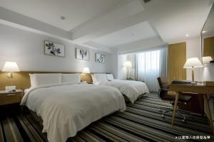 台中市卡尔登饭店台中馆的酒店客房配有两张床和一张书桌