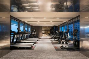 台中市顺天环汇酒店的健身房,配有一排跑步机和机器