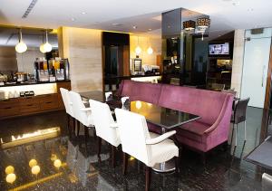 高雄御宿国际商旅-中山馆的一间用餐室,配有紫色的沙发和白色的椅子