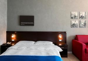墨西拿安诺齐亚塔住宿酒店的一间卧室配有一张大床和一张红色椅子