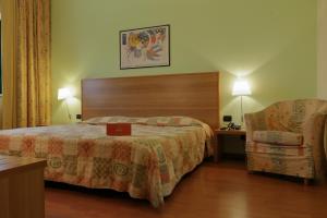 福萨诺罗曼尼西欧酒店的配有一张床和一把椅子的酒店客房