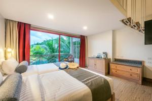 奥南海滩Chada Thai Village的一间卧室设有一张大床和一个大窗户