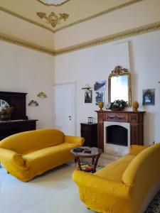 锡拉库扎卡萨蜜雅酒店的客厅配有黄色沙发和镜子