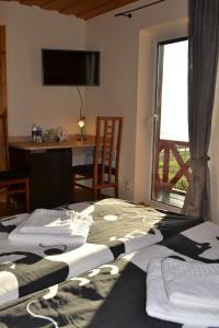 奈达马里乌克兰塔斯旅馆的一间卧室设有两张床、一张桌子和一个窗口。