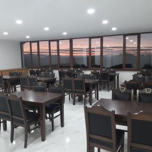 凡城Toprak Hotel的餐厅设有桌椅,享有日落美景。