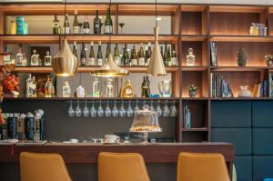 卢布尔雅那Hotel Mrak Superior的架子上装有椅子和瓶子的酒吧