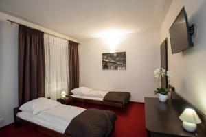 TargowiskoRestauracja Hotel Graal的一间酒店客房,设有两张床和电视