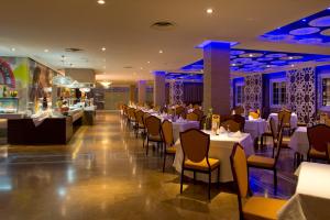 莫特里尔厄尔巴莫特里尔海滩商务酒店的一间设有白色桌椅的餐厅和一间酒吧