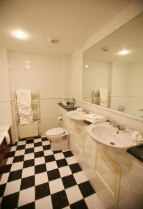 利敦瓦纳Sheedys Boutique Hotel & Restaurant的浴室设有2个水槽、卫生间和镜子。