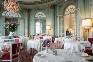 蒙巴宗阿尔蒂尼城堡酒店的一间配备有白色桌椅和吊灯的餐厅