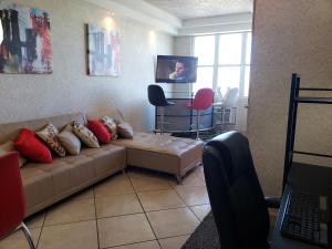 圣胡安Apt in San Juan, 4 guests max, 1 BR-1 BTH, Full kitchen, Free Internet-Parking的带沙发和电视的客厅