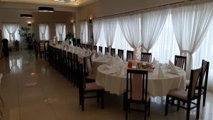 TargowiskoRestauracja Hotel Graal的一间长餐厅,配有白色的桌子和椅子