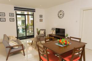 阿克拉Accra Luxury Apartments @ The Gardens的客厅配有桌椅和电视。