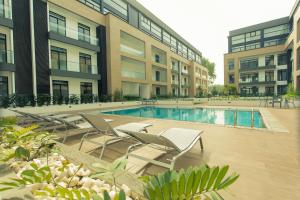 阿克拉Accra Luxury Apartments @ The Gardens的一座大楼前的游泳池,配有躺椅