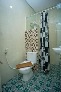 沙马林达Zoom Hotel Mulawarman的浴室配有卫生间、淋浴和盥洗盆。