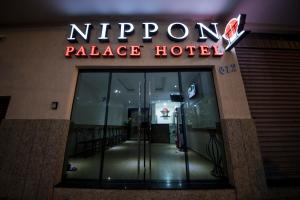 阿帕雷西达Nippon Palace Hotel的 ⁇ 虹灯标志的酒店入口