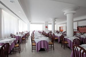 马帝斯兹罗Hotel Belvedere的用餐室配有桌椅和紫色桌布