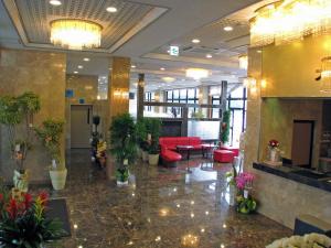 熊野市Hotel Nami的大厅,在大楼里摆放着红色家具和植物